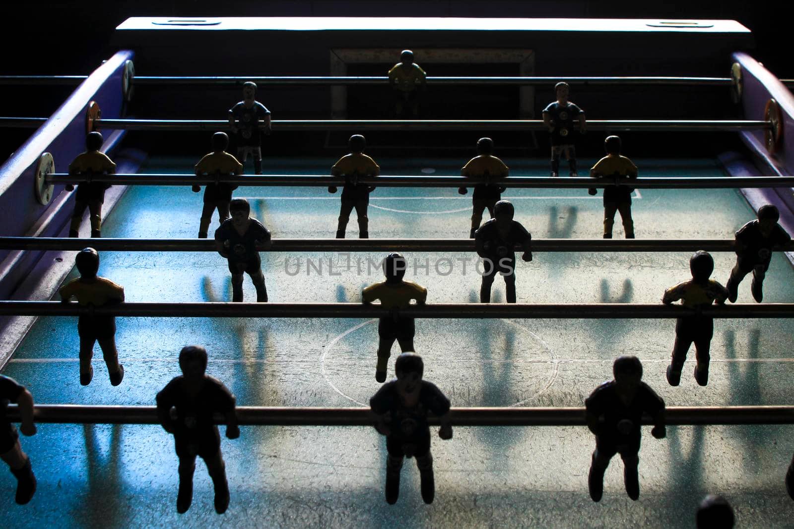 Old foosball table players in a row in a bar in Spain