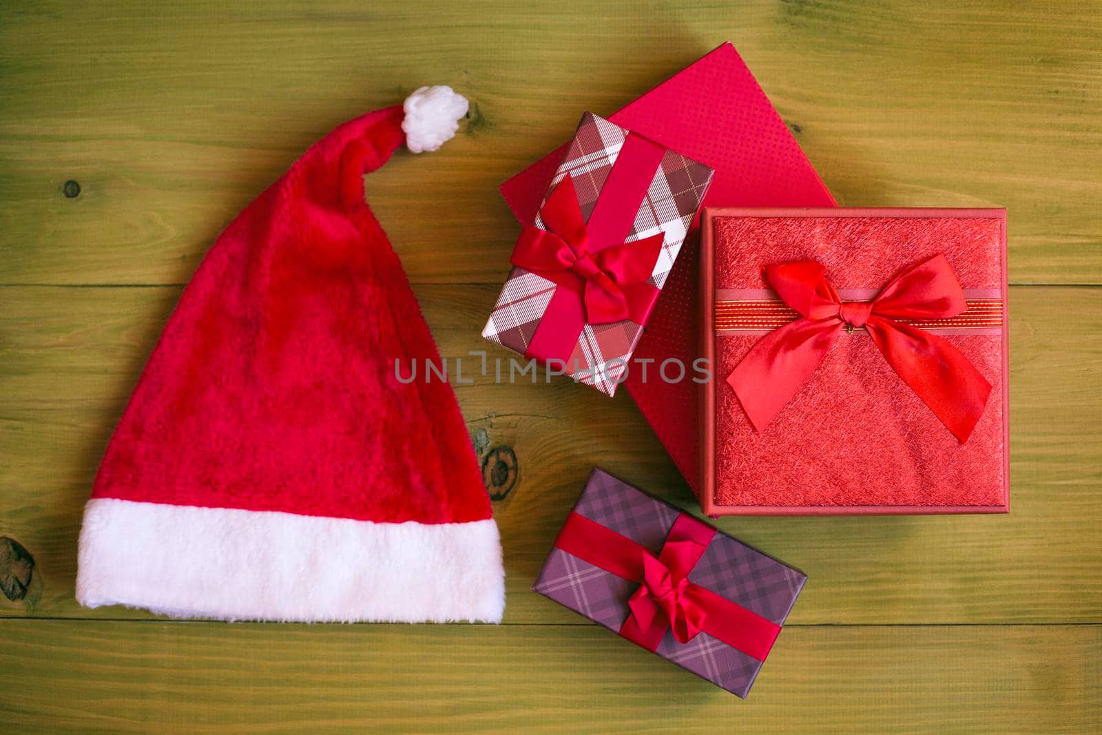 Image of Santa Hat and gifts on wooden table.