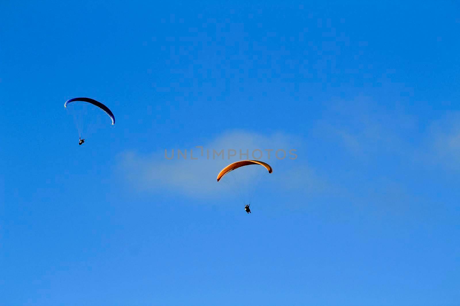 People paragliding in Santa Pola on a sunny day of Autumn