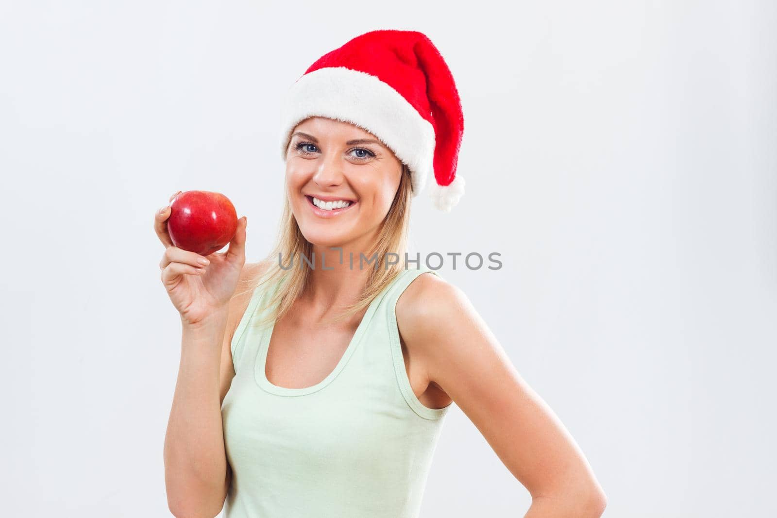 Beautiful woman with Santa hat holding apple.