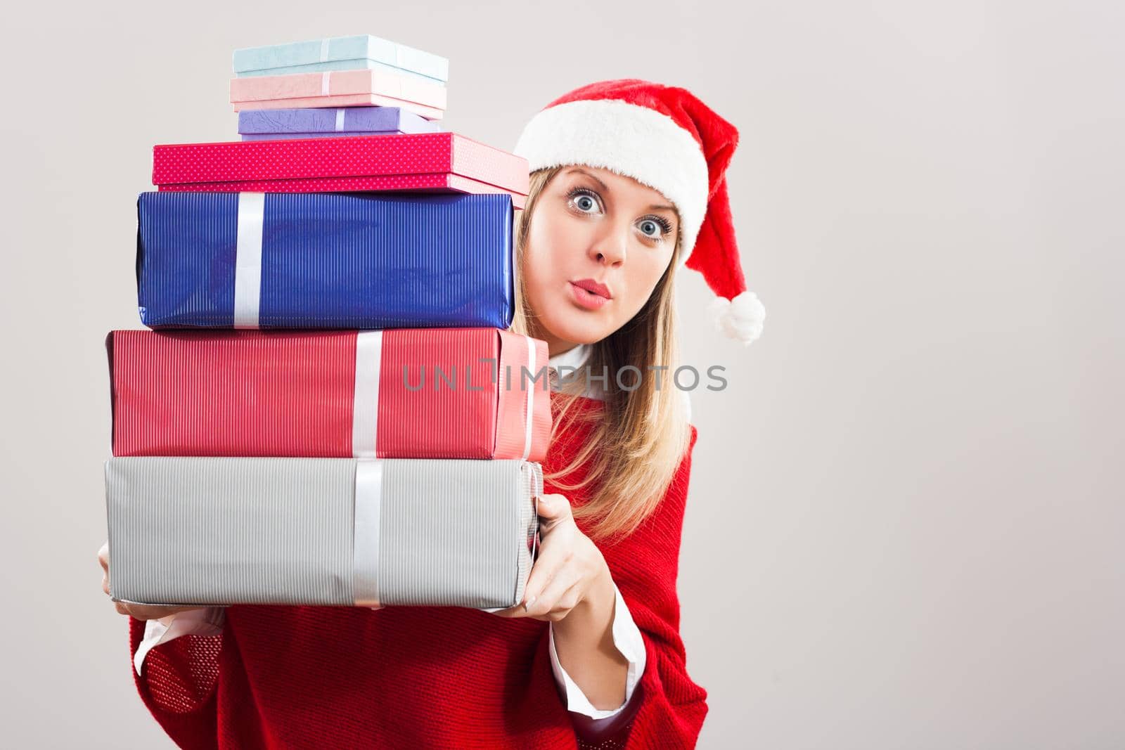 Image of  excited  young woman holding Christmas presents.