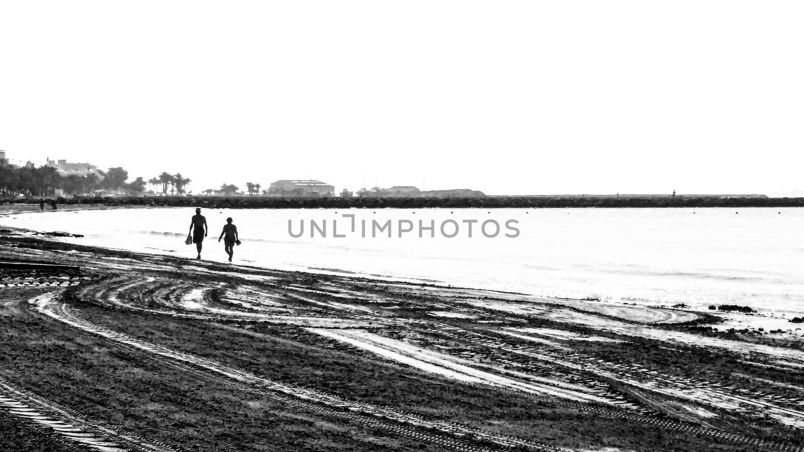 Couple walking by the seashore in a sunny day in Santa Pola, Alicante