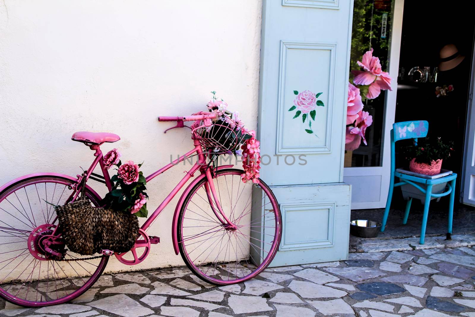 Pink vintage bicycle with flowers at the entrance of a decoration shop in Spain