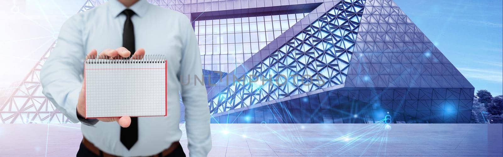 Man Wearing Black Tie Holding Notebook Around Futuristic Technology.