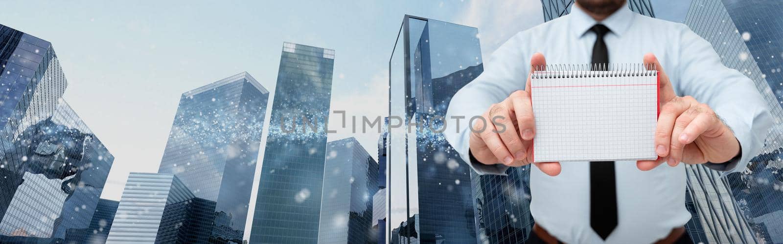 Businessman Holding Empty Page Graphing Notebook With His Both Hands Around Futuristic Technology. Employee Presenting Blank Workbook Surrounded By Modern Automation. by nialowwa