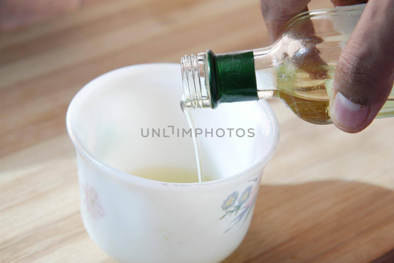 detail shot of Pouring vegetable oil in a cup .