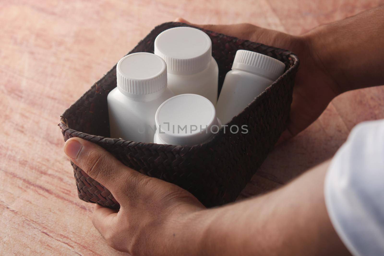 young man hand holding many medicine pill container white sited ,