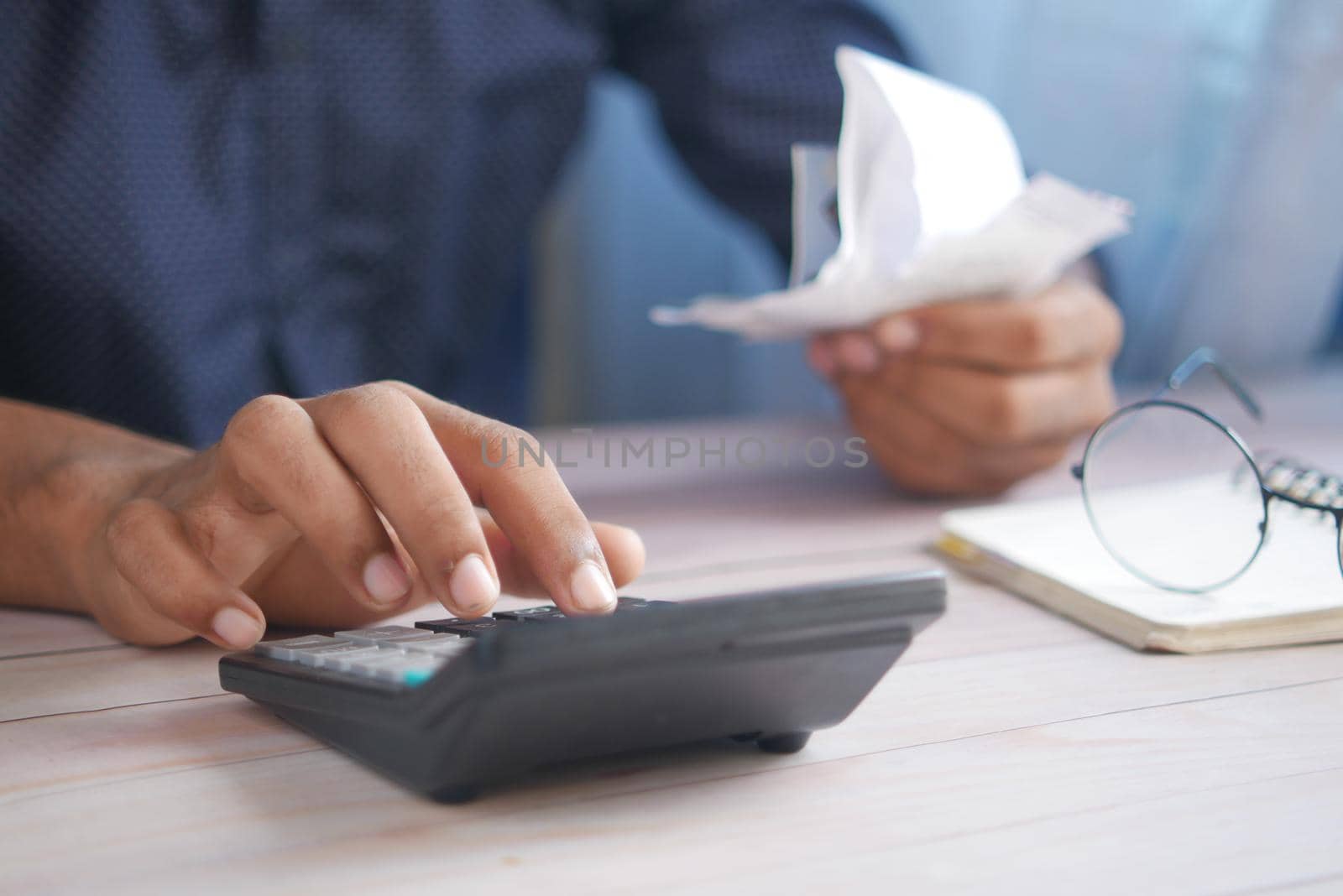 Close up of man hand using calculator.