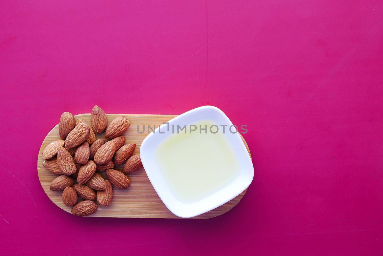 Almond oil in bottle on wooden background