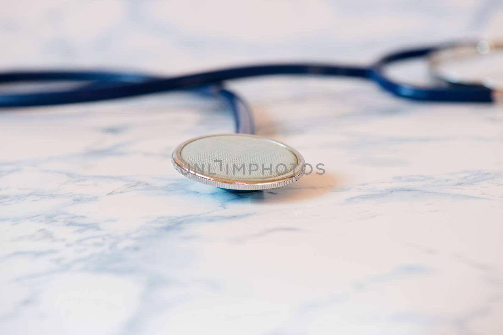 Macro shot of medical stethoscope or phonendoscope over light blue background.