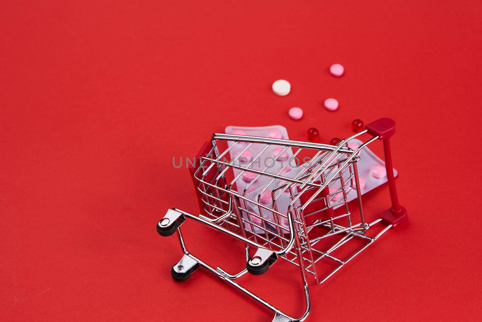 trolley with medicines on a red background Pharmaceuticals pills. High quality photo