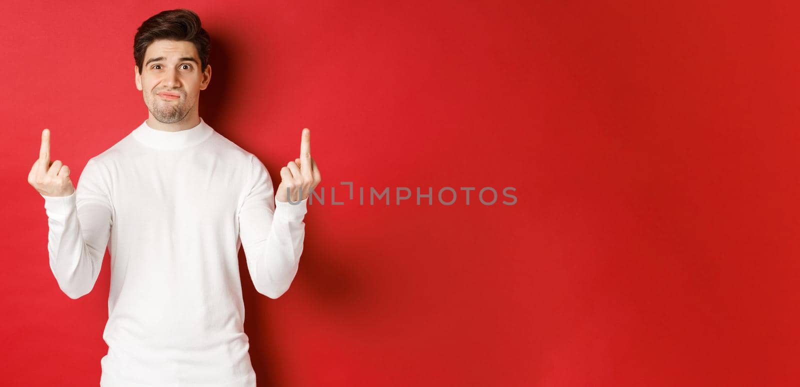 Image of pissed-off and distressed man telling to fuck off, showing middle-fingers and looking upset, standing over red background in white sweater by Benzoix