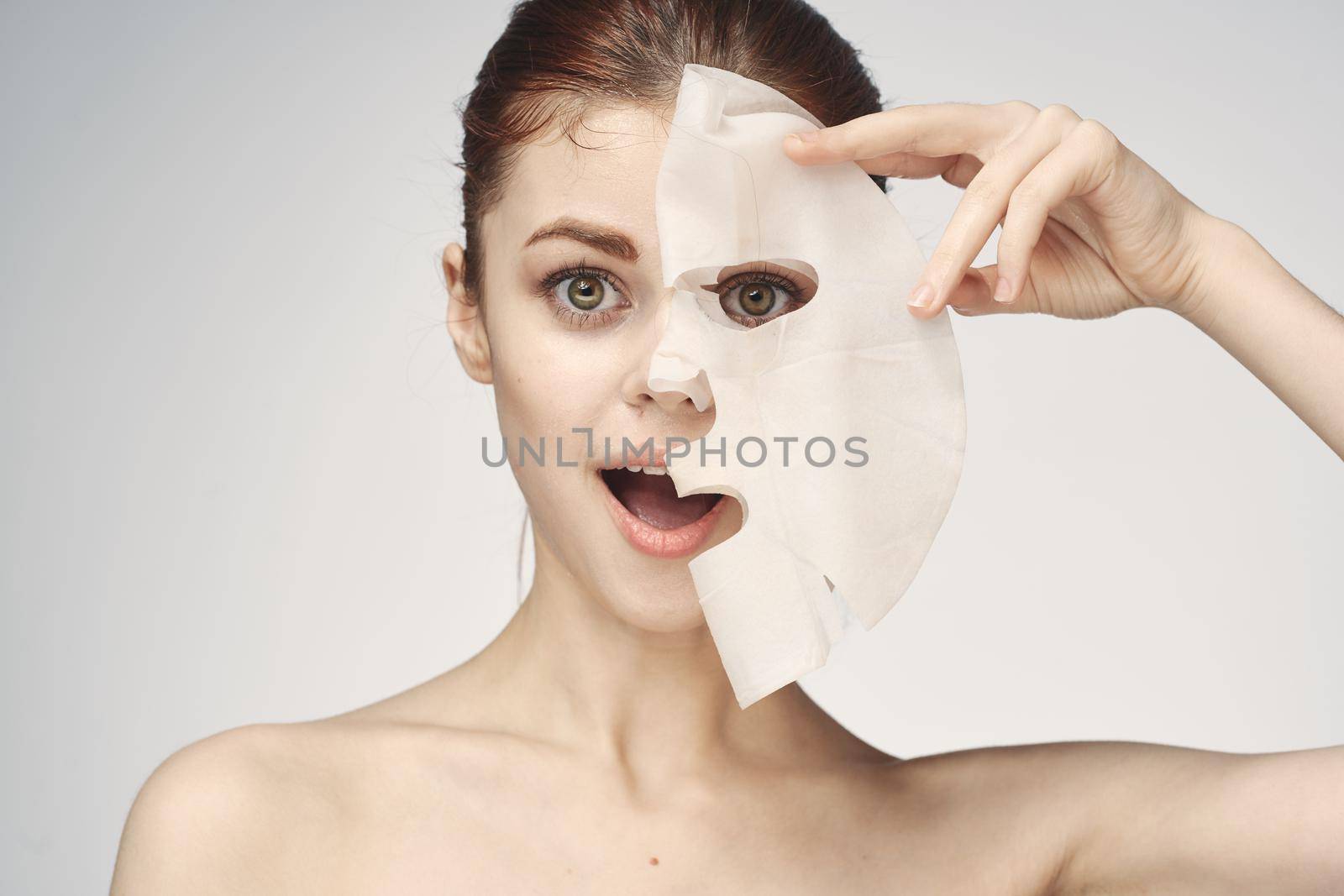 woman with bare shoulders and face mask skin care cosmetics. High quality photo