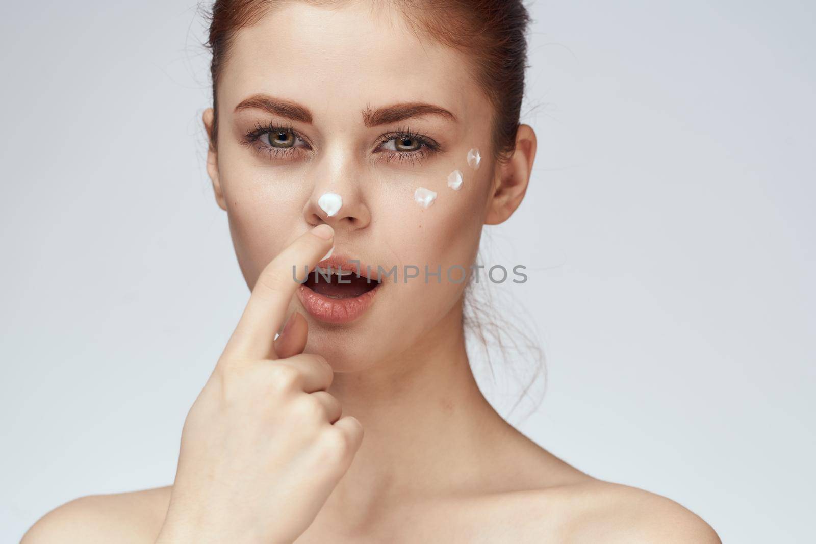 woman with face cream naked shoulders cosmetics face care. High quality photo