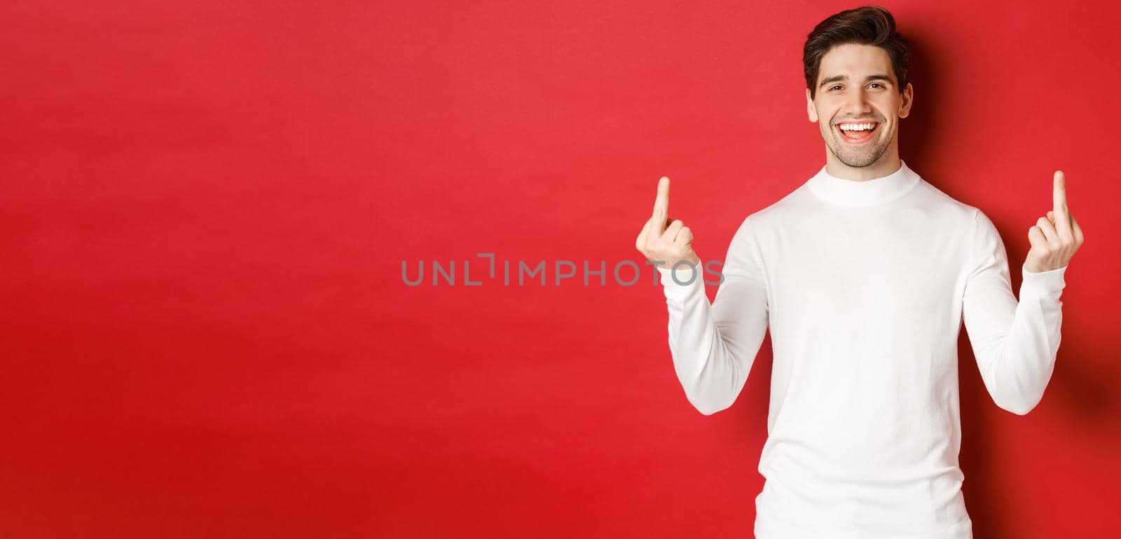 Image of rude and unbothered man laughing while showing middle-fingers, telling to fuck-off, standing over red background by Benzoix