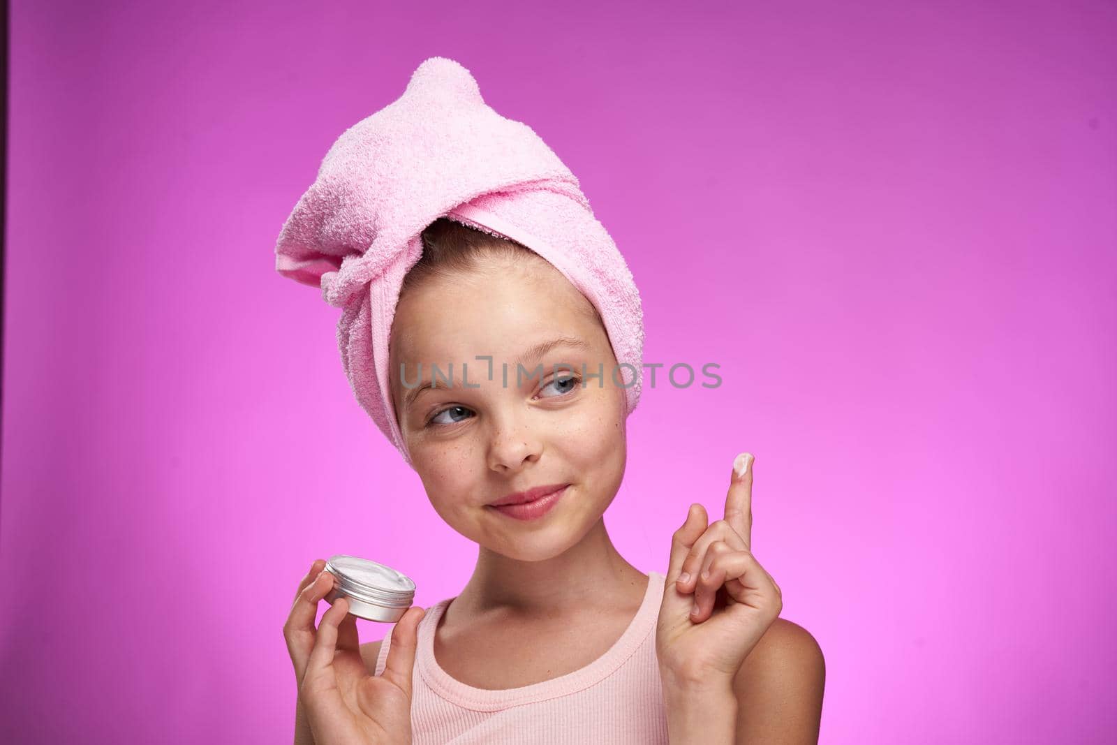 girl with a towel on her head cosmetics decoration close-up purple background. High quality photo