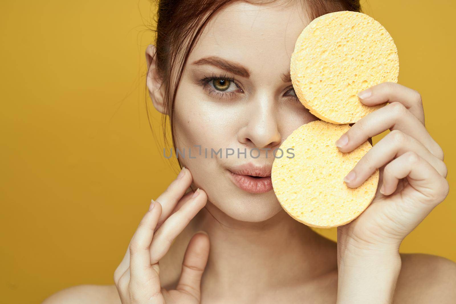 pretty woman with sponges in her hands bare shoulders clean skin hygiene. High quality photo