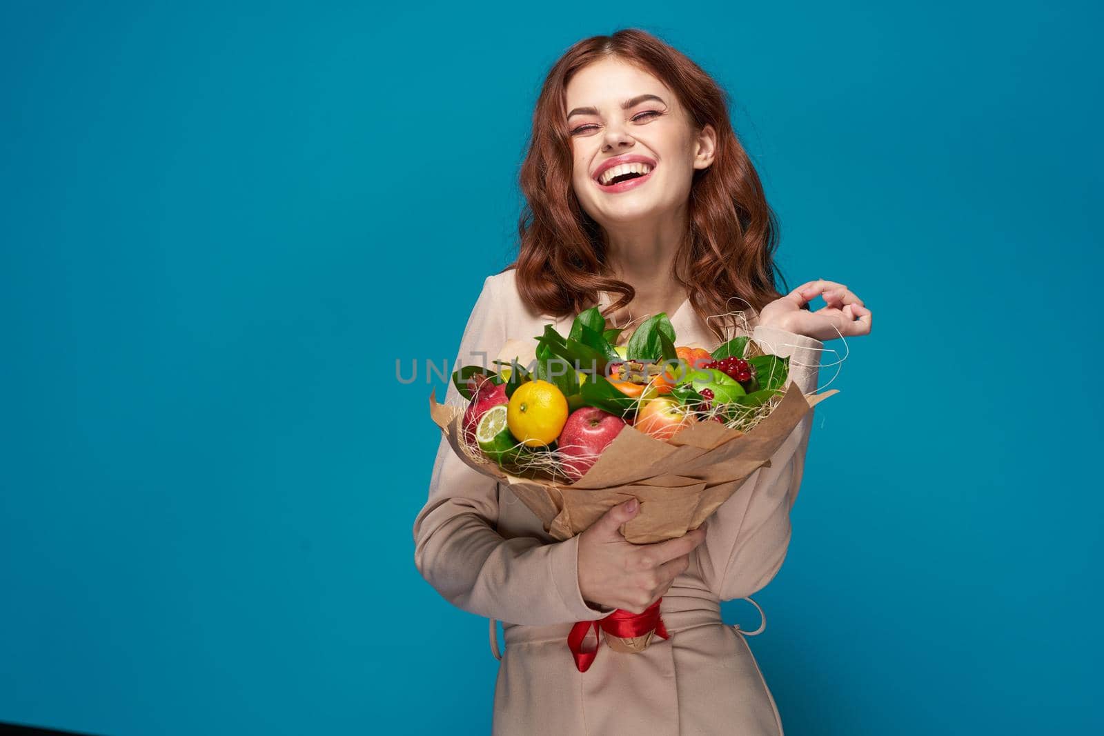 pretty woman beige coat fruit bouquet in hands isolated background. High quality photo