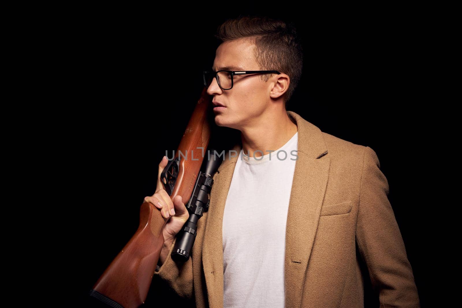 portrait of a man with a gun in hand security hunter isolated background by Vichizh