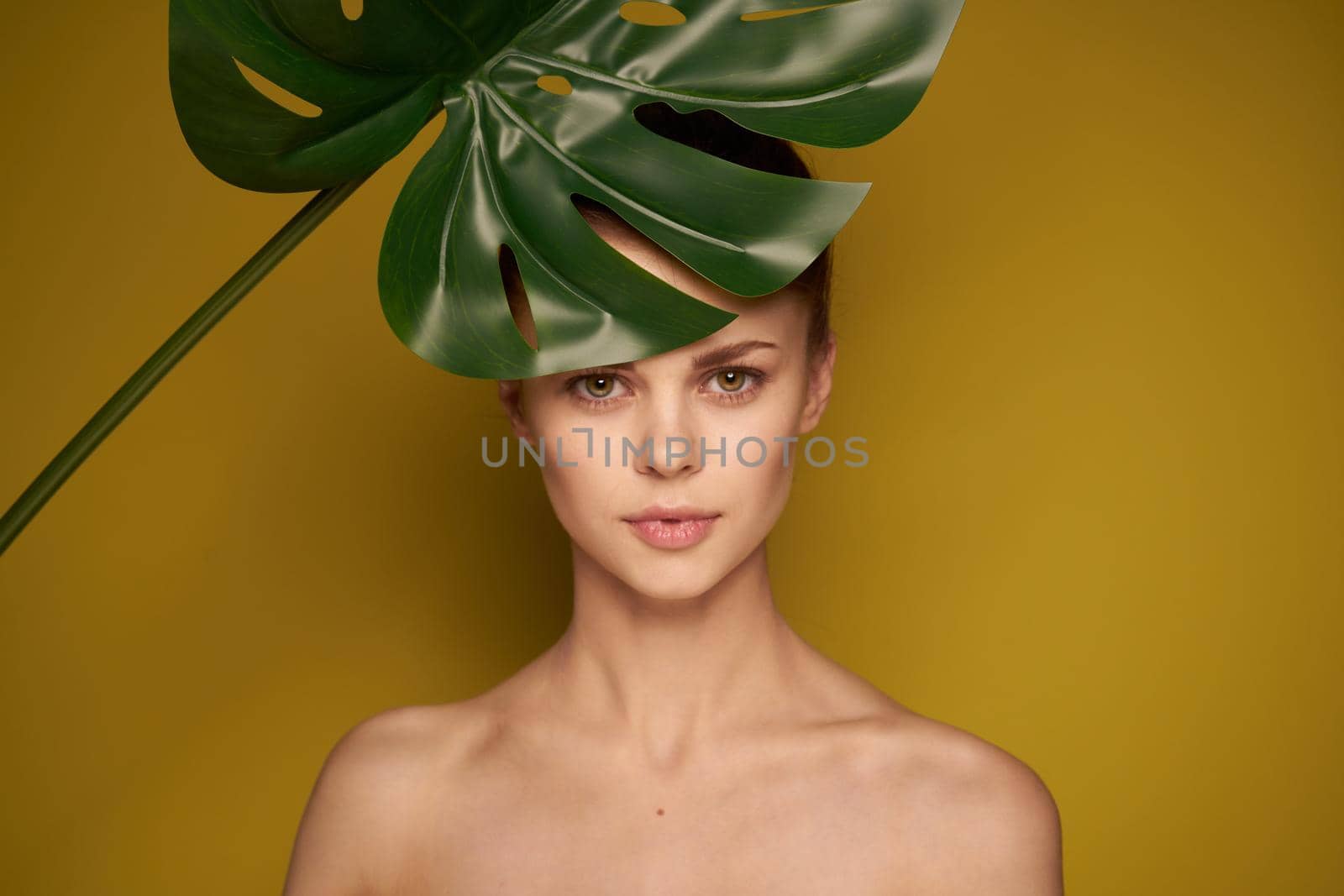 pretty woman palm leaf bare shoulders isolated background. High quality photo