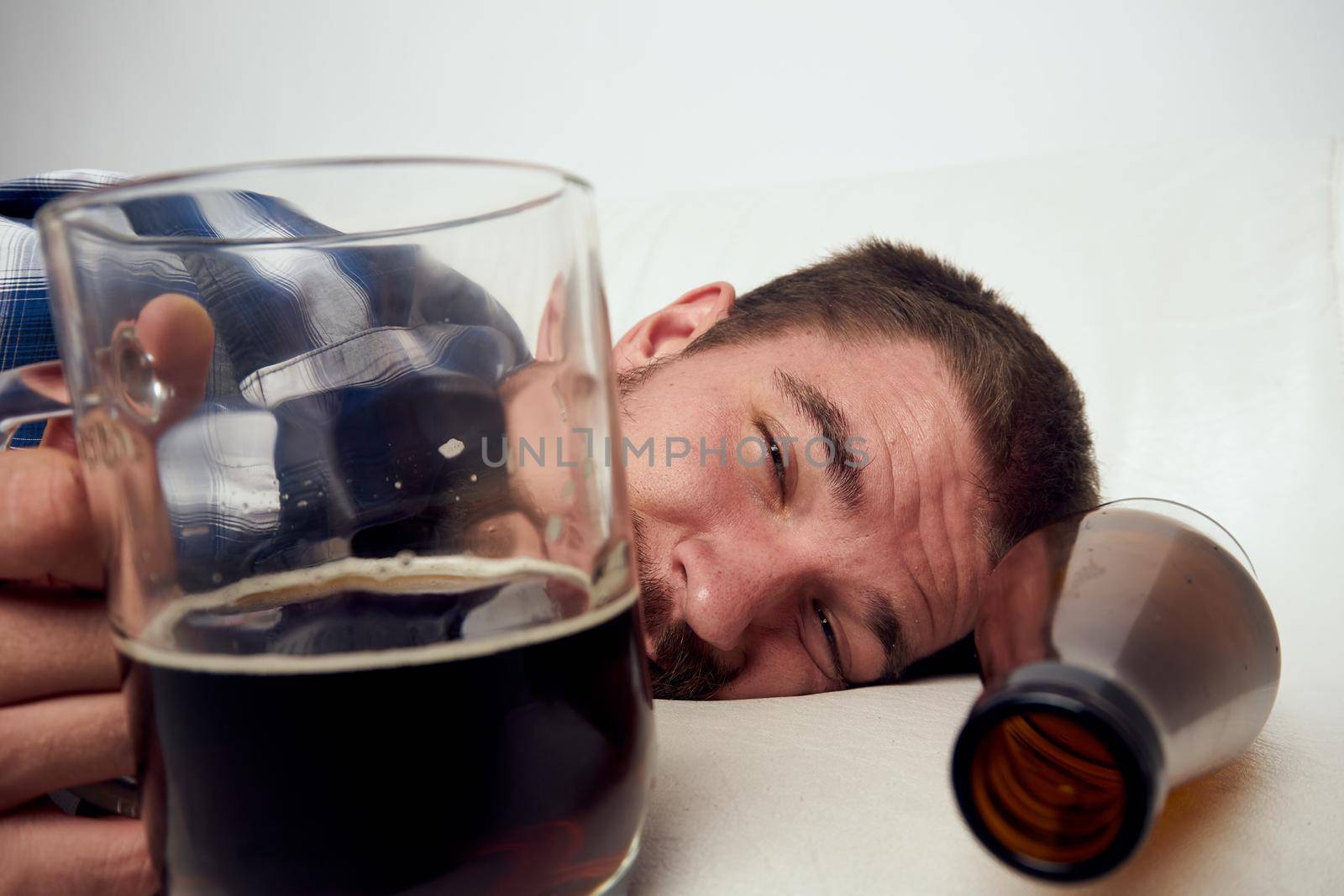 drunk man drinking beer alcohol emotion light background by Vichizh