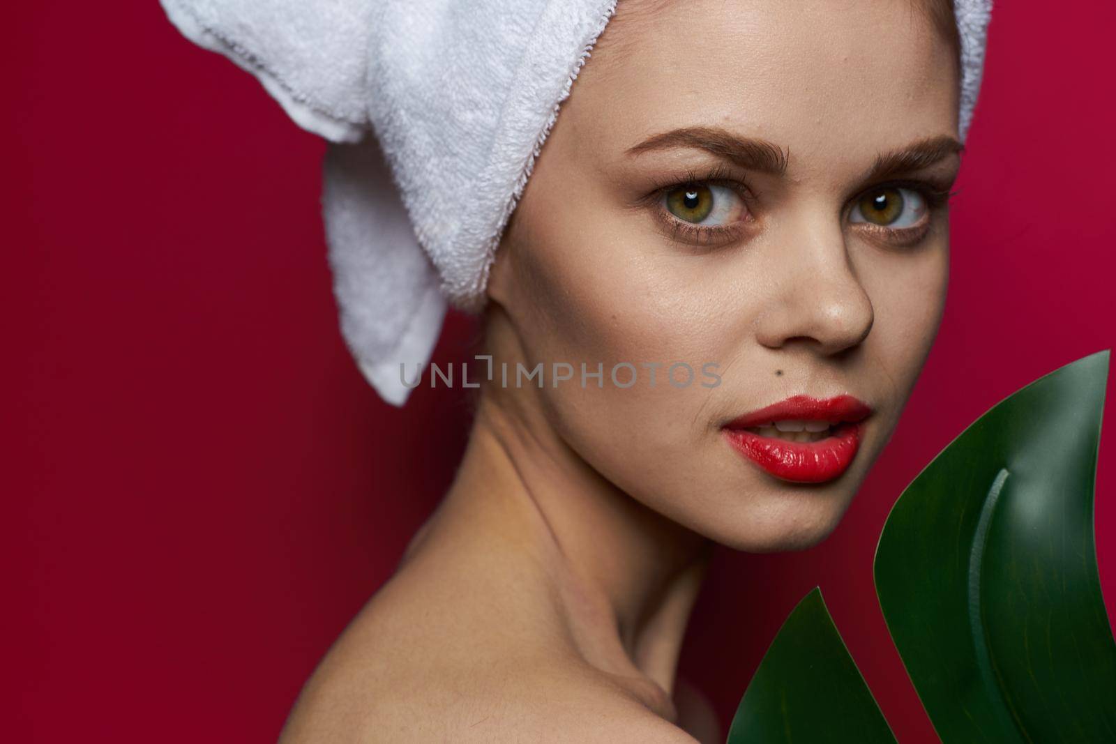 beautiful woman with a towel on my head body care red background. High quality photo