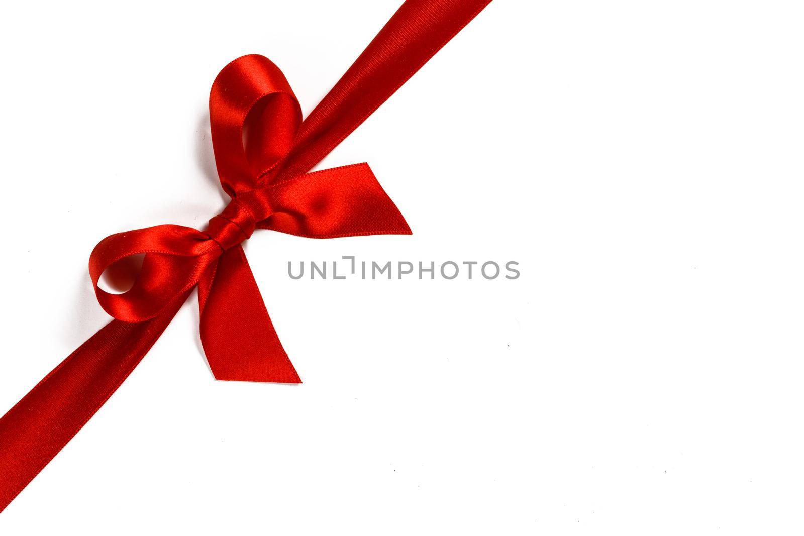 Big red satin bow isolated on white background. Christmas holiday gift concept