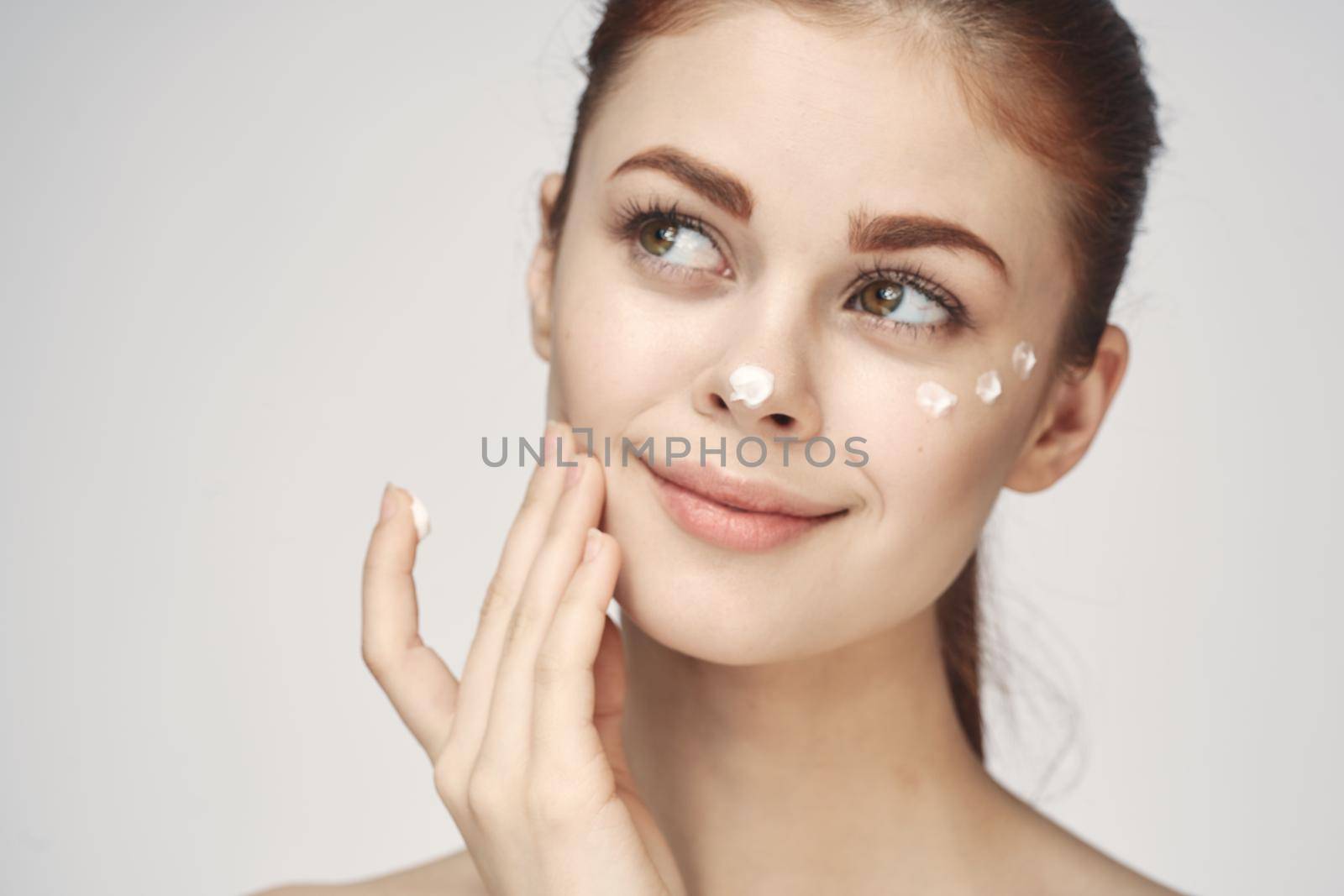 woman with face cream naked shoulders cosmetics face care. High quality photo