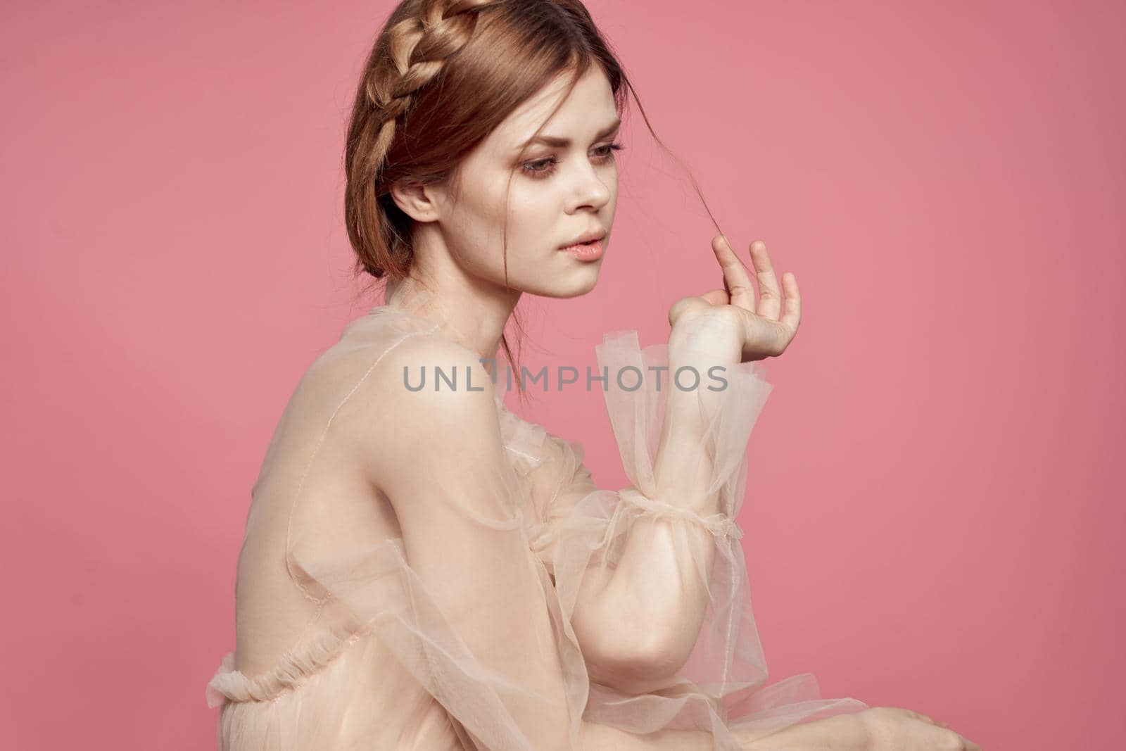 pretty woman in dress fashion hairstyle posing luxury pink background. High quality photo