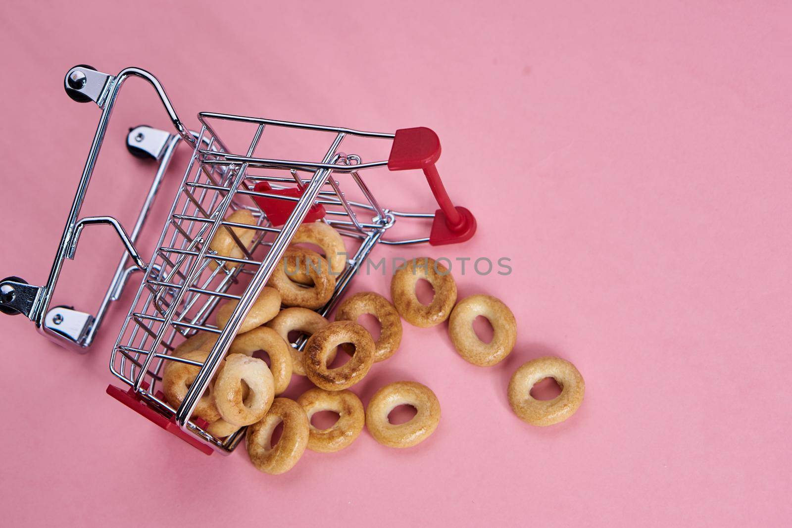small shopping carts supermarket shopping pink background. High quality photo