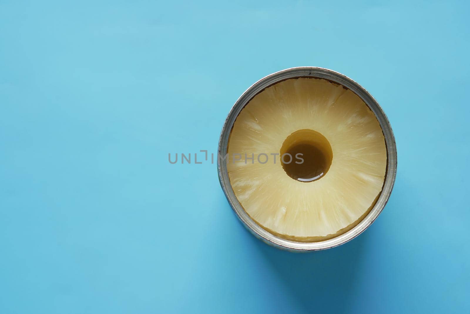 a open can of pineapple on table with copy space ,