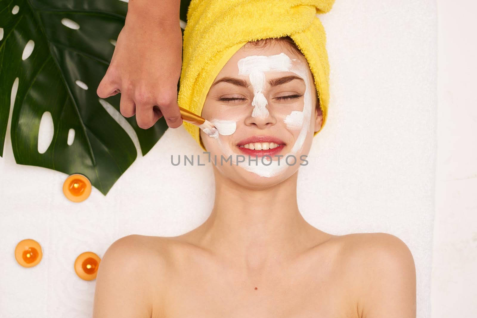 cheerful woman with a towel on my head skin care light background. High quality photo