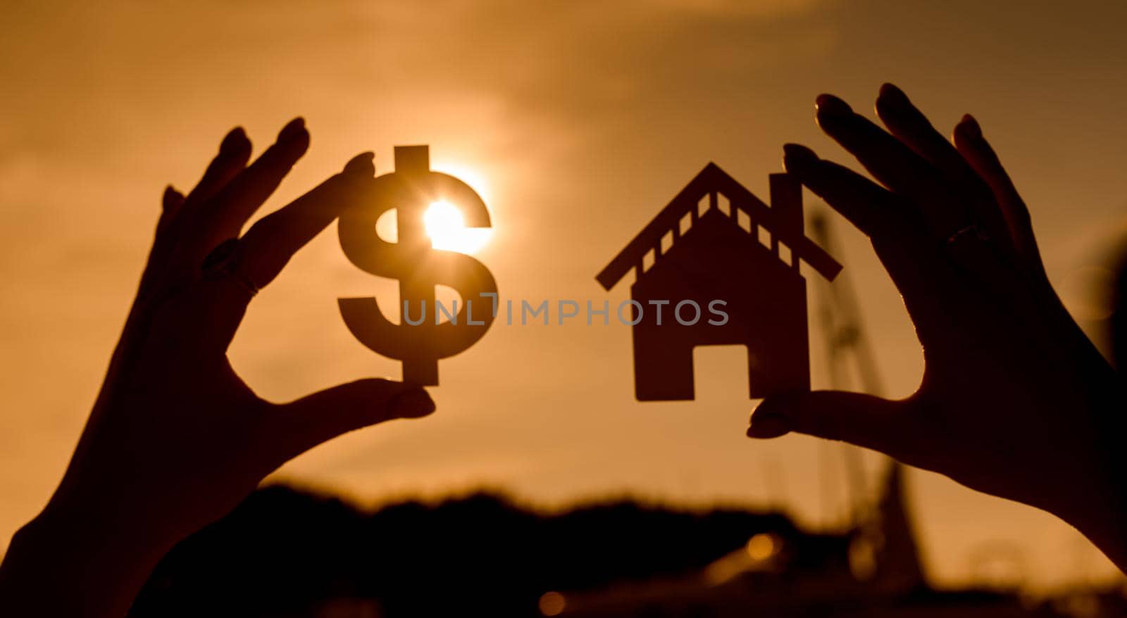 symbol of the dollar and the house at sunset in the form of contours in women's hands by AntonIlchanka