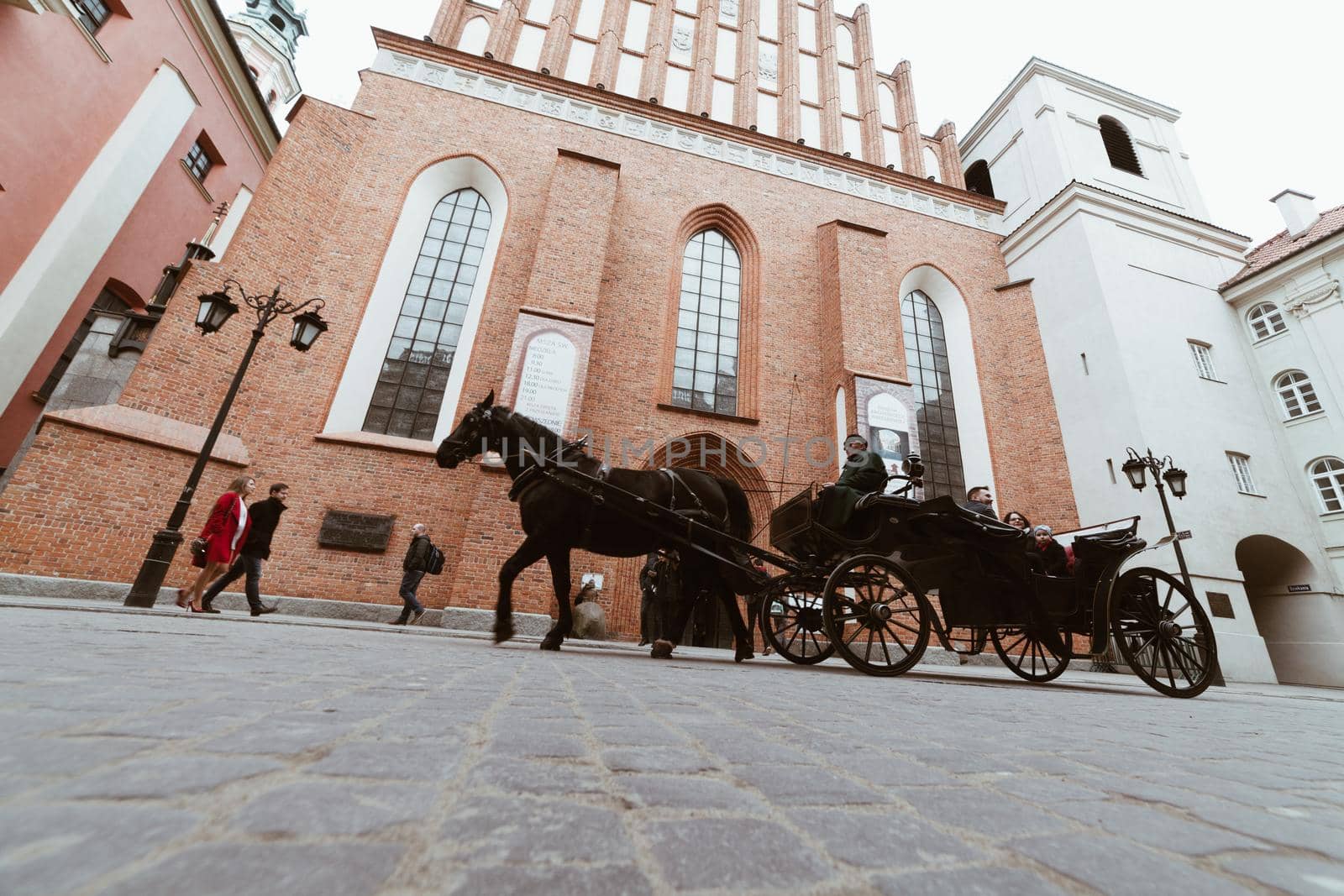 WARSAW, POLAND - Mar, 2018 Tourists ride in a carriage with horses in the historic part of the city of Warsaw 1