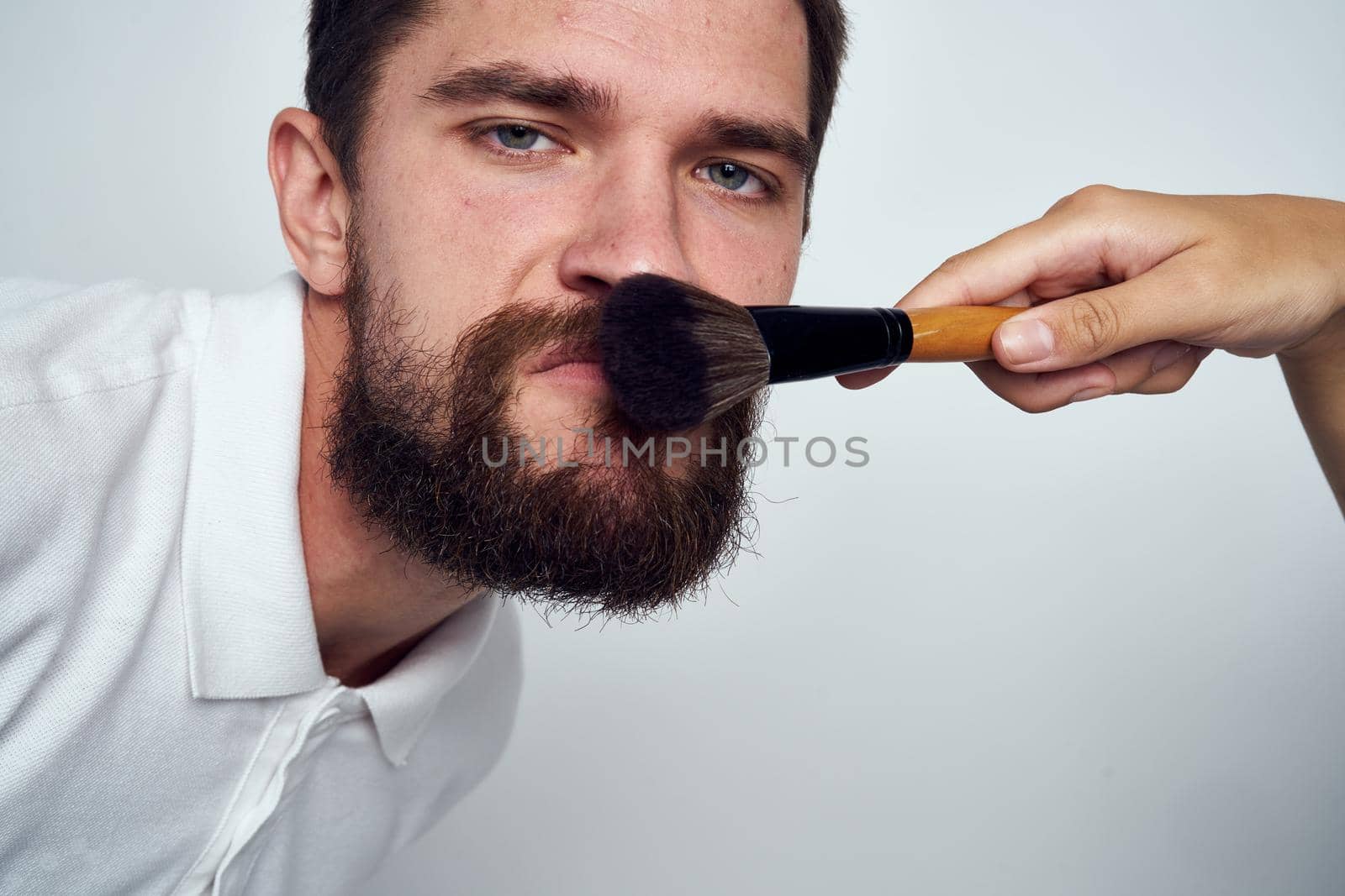 bearded man makeup cosmetics skin care light background. High quality photo