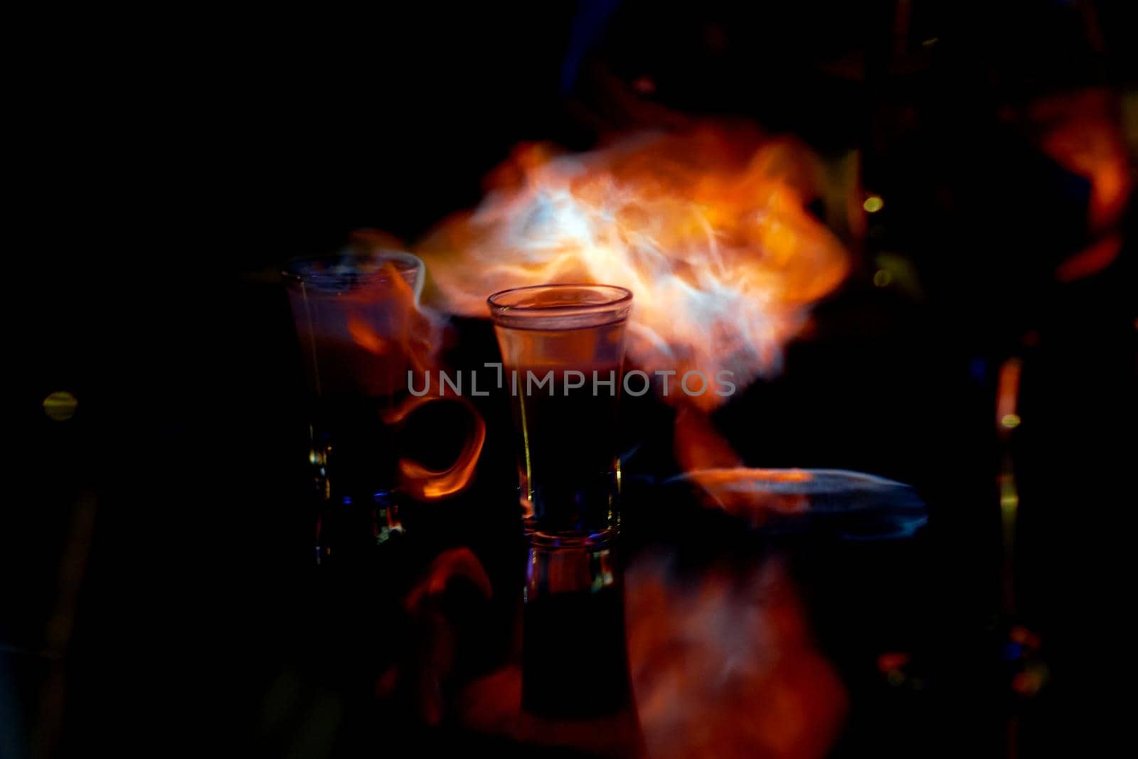 A glass of wine sitting on top of a fire. High quality photo