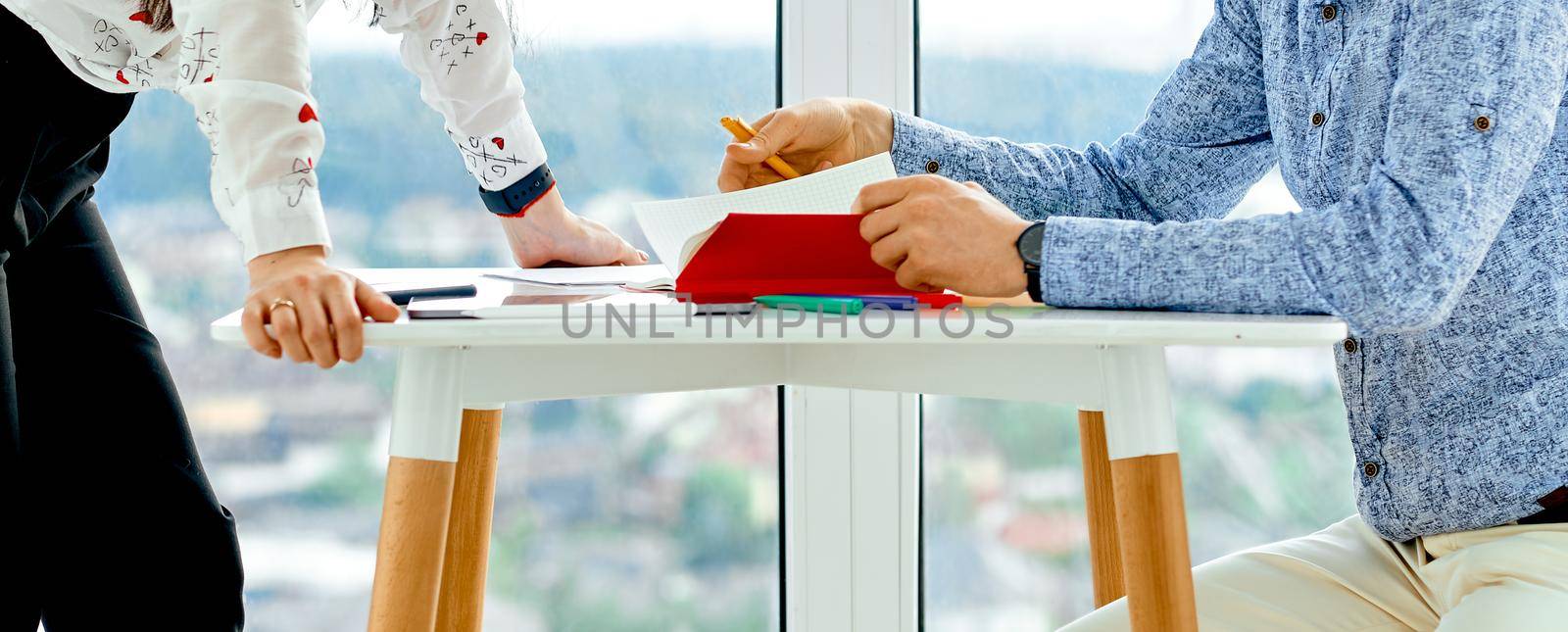 man and woman discuss notes in red notebook. High quality photo