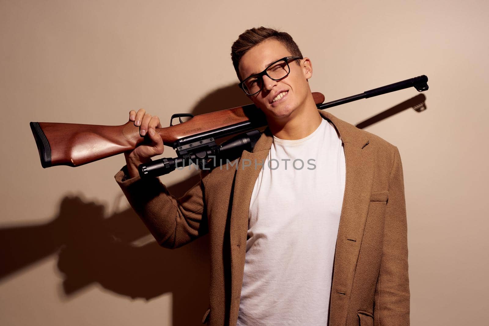 portrait of a man posing with glasses with a rifle in his hands isolated background by Vichizh