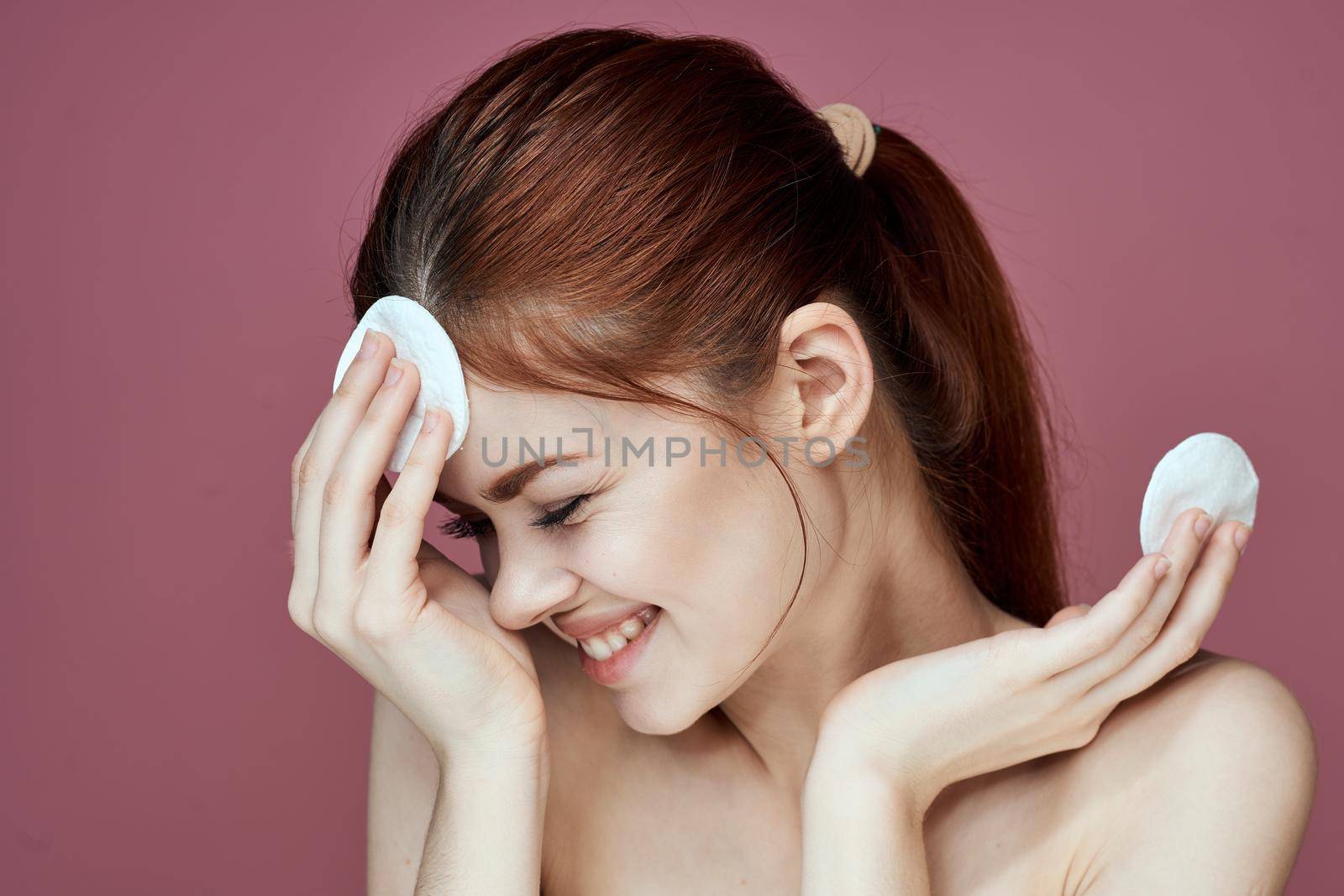 woman with bare shoulders cotton pads pure skin charm pink background. High quality photo