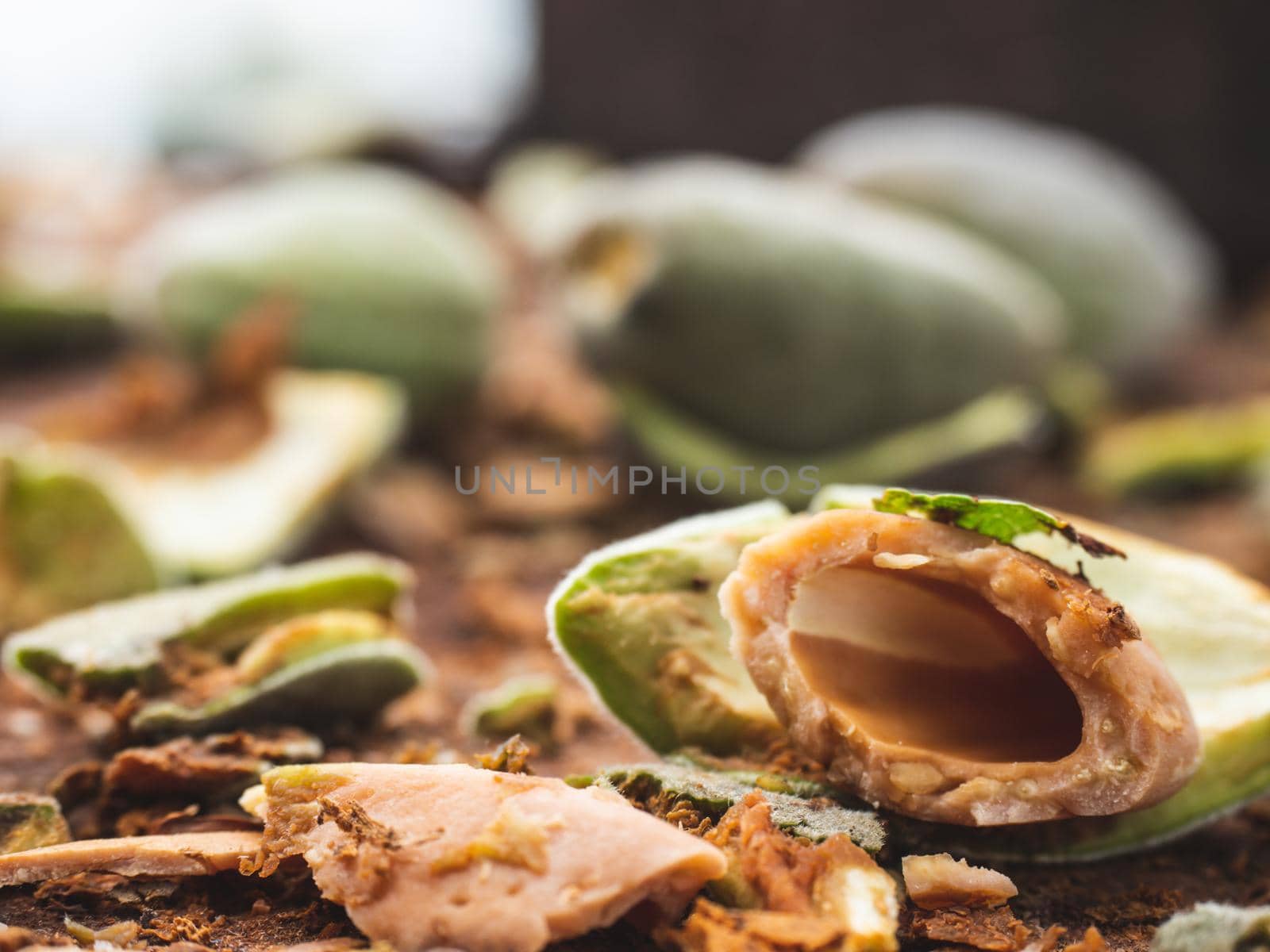 Cracked almond  nuts, shells and peeling fresh almonds from green husks. Testing fresh almonds taste