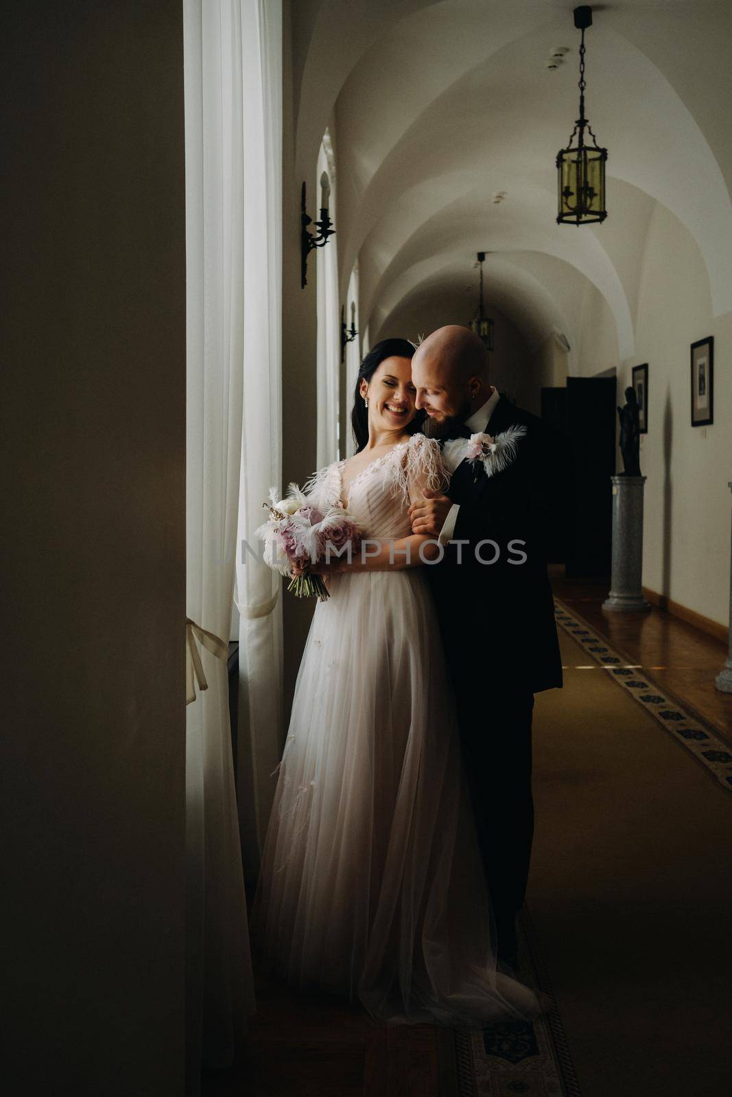 Elegant wedding couple in the interior of the old castle in the city of Nesvizh by Lobachad