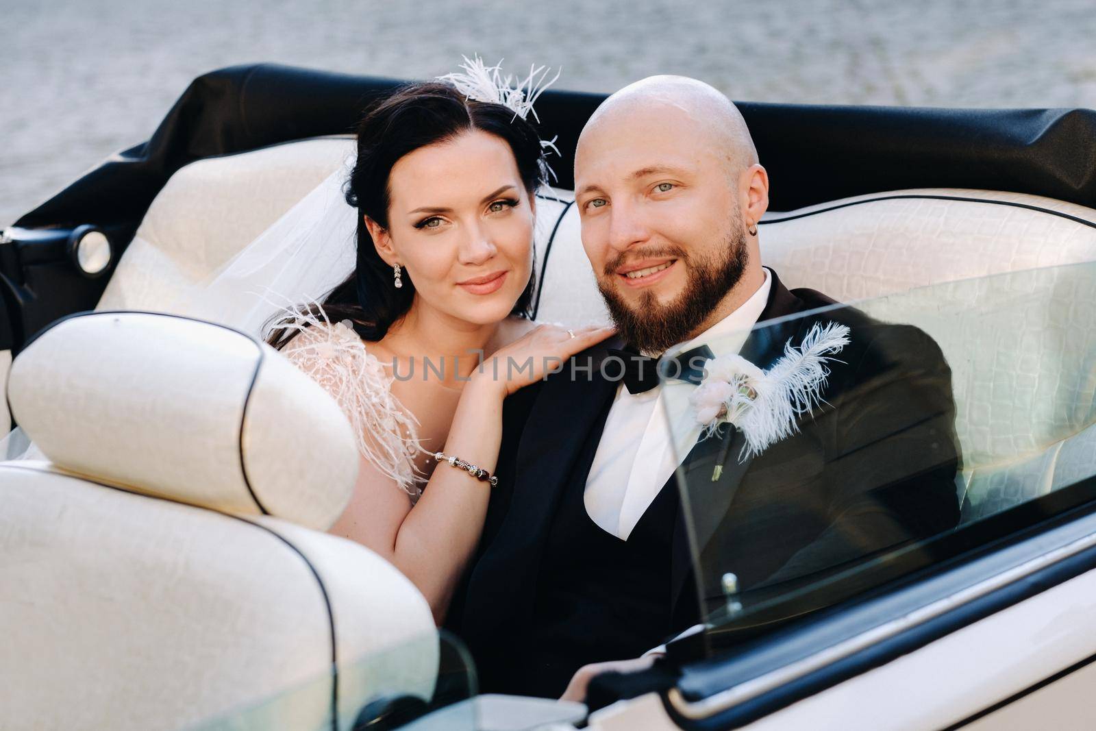 Elegant wedding couple In the courtyard of the castle in a retro car.