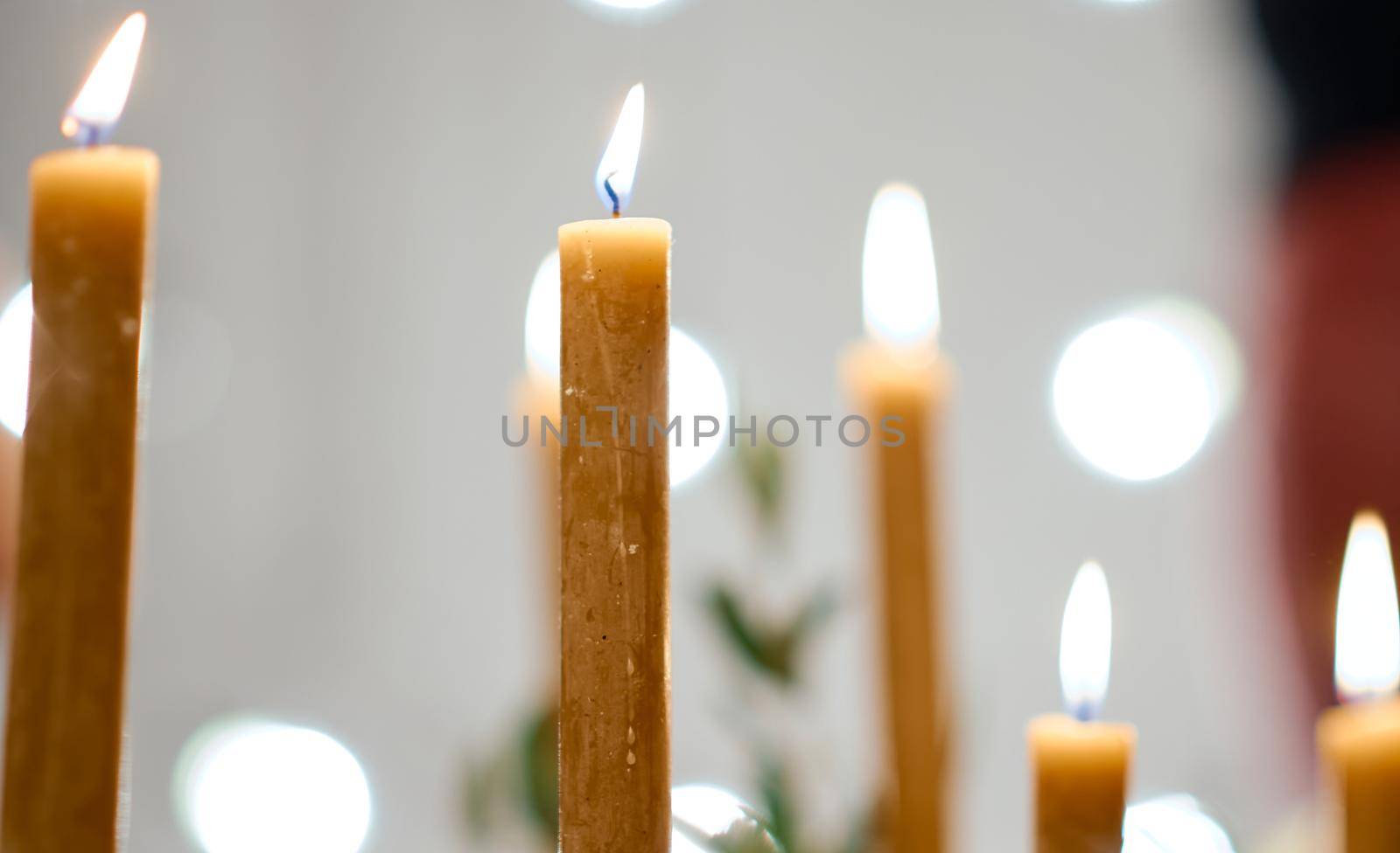 Beautiful burning candles and fairy lights at table with bokeh. High quality photo