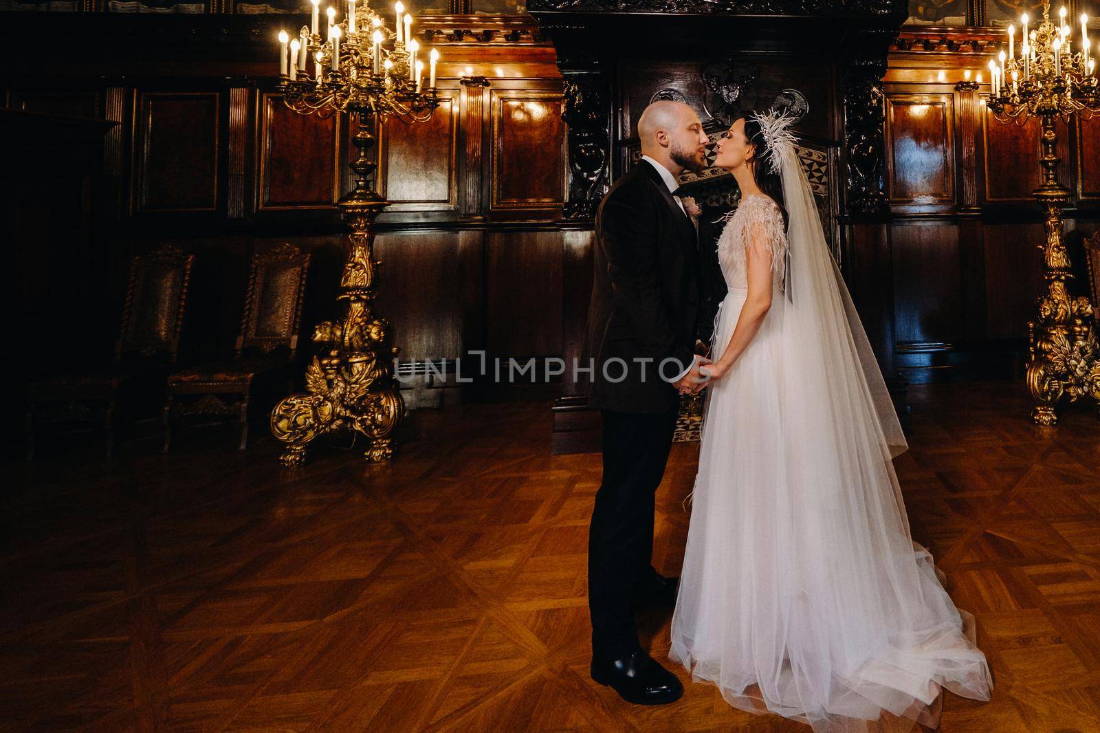 Elegant wedding couple in the interior of the old castle in the city of Nesvizh by Lobachad