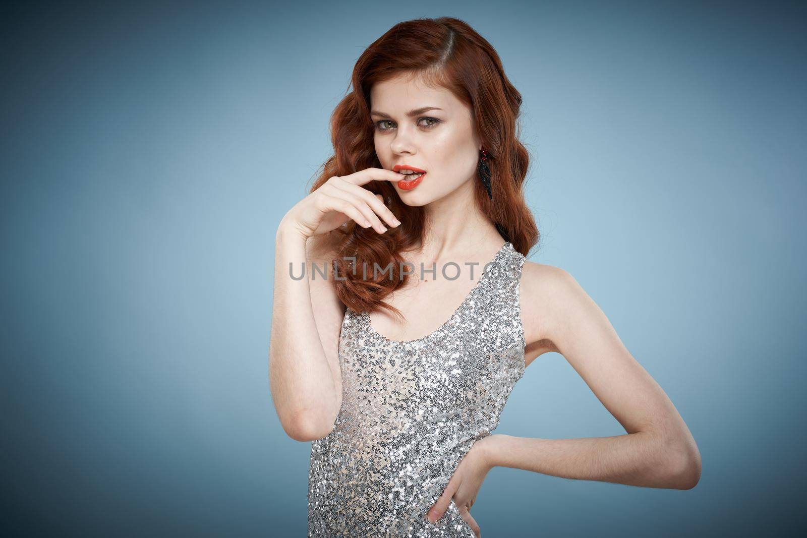 woman in silver evening dress posing blue background luxury by Vichizh