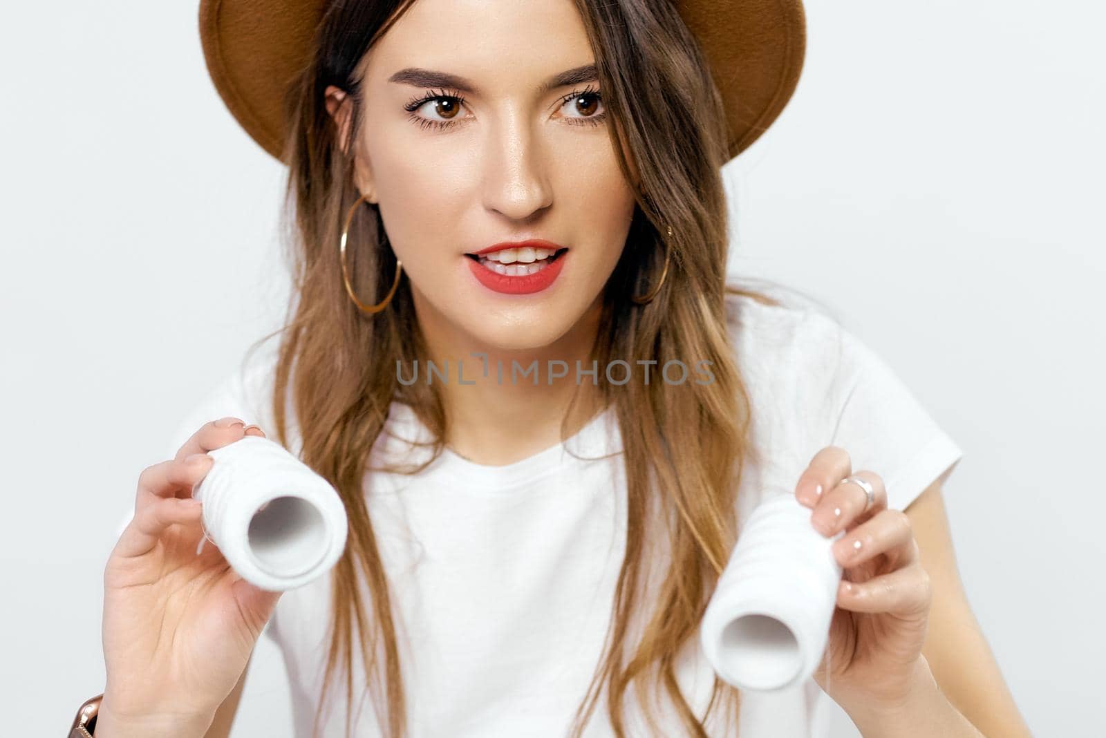 Happy girl in hat with coils of threads near eyes. High quality photo