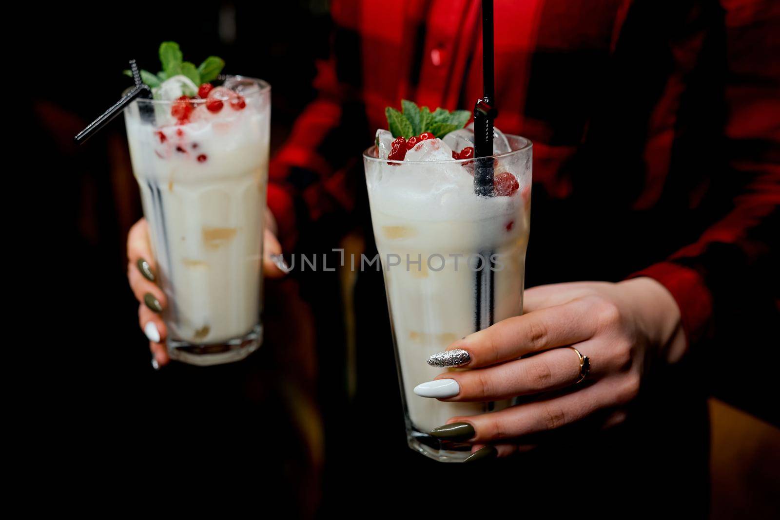 Girl waiter with two milkshakes in hand. High quality photo