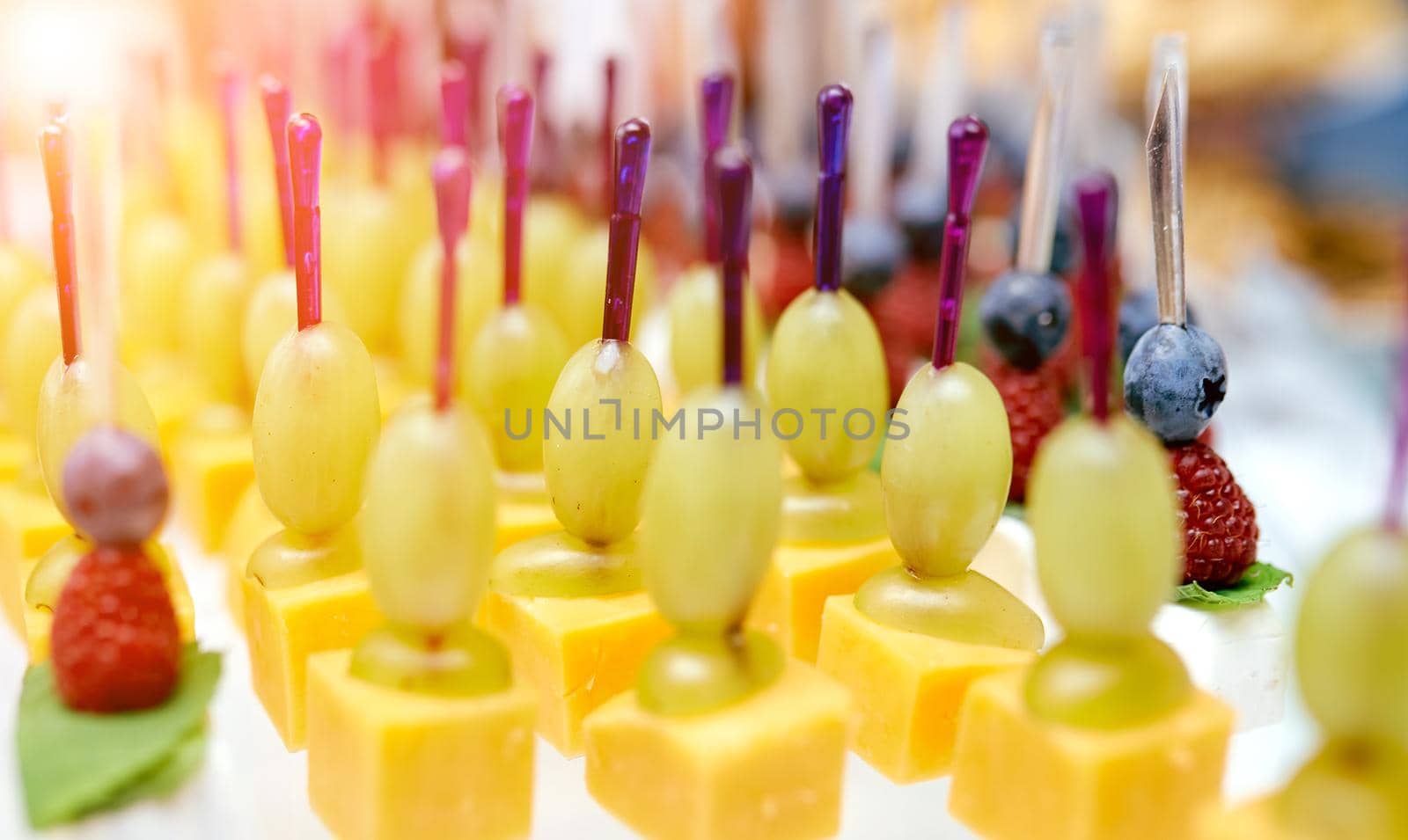 Catering. On the table cheese, grapes, blueberries, blackberry on skewers . High quality photo