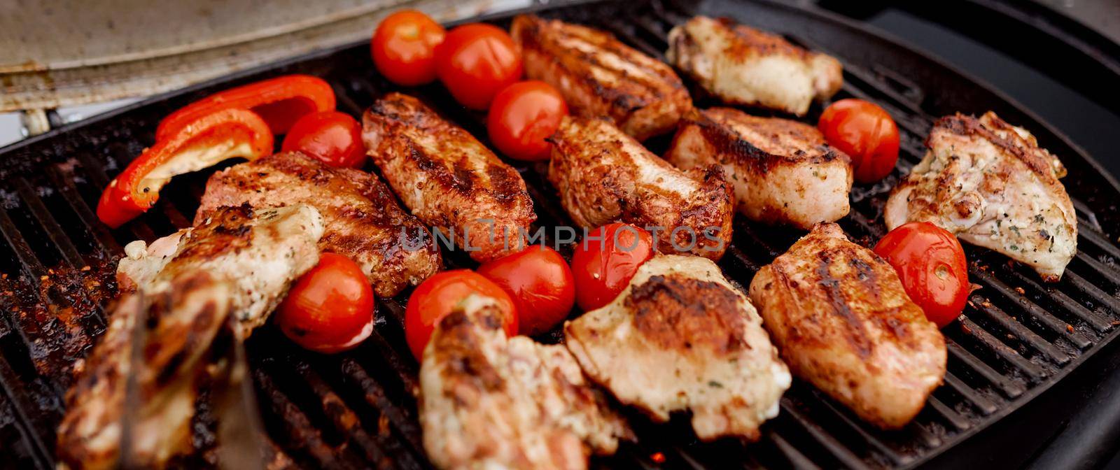 juicy roasted meat, tomatoes, red pepper on the grill on the street. High quality photo