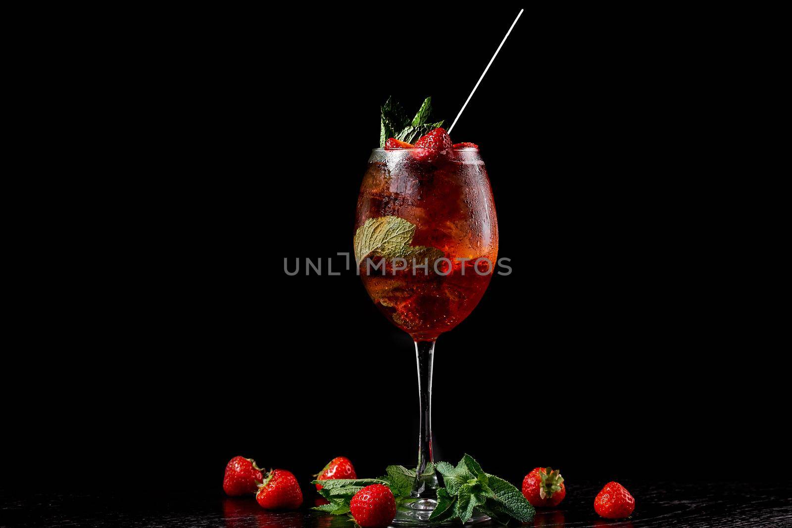 Cocktail in a glass with a tube on a black background with mint. High quality photo